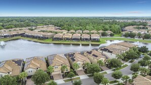 A residential area with houses, a body of water, and a distant view of a city skyline. - Windsor Westside Beautiful 8BR Villa with Pool/Spa (Kissimmee)