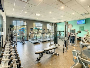 Ein Fitnessstudio mit Laufbändern, Hanteln und Kraftgeräten.