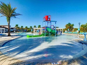 A water park with a pool, slides, and a red water feature. - 8BR Villa with Pool & Spa, Near Disney (Kissimmee)