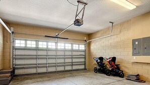 Eine Garage mit einer großen Metalldo, einem an der Decke befestigten Projektor und einem Kinderwagen.