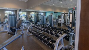 Ein Fitnessstudio mit unterschiedlichen Trainingsgeräten, darunter Kurzhanteln und Kraftmaschinen.