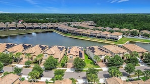 A residential area with houses, a lake, and a road. - Windsor Westside 8BR Lake View Home Near Disney (Kissimmee)
