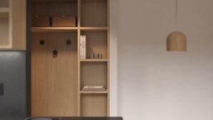 Una cocina moderna con estufa integrada, armarios de madera y un comedor con mesa y silla.