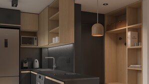 Una cocina moderna con lavadora incorporada, microondas y comedor con mesa y sillas.