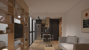 Una sala de estar moderna con un sofá, un televisor y una zona de comedor con sillas y una mesa.