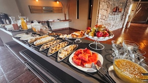 A buffet with various food items and a fruit display.