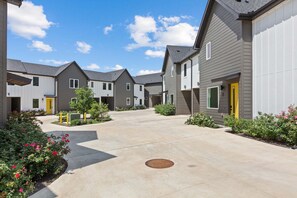 A residential area with multiple houses, a central walkway, and small gardens.