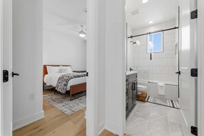 A modern bathroom with a shower, toilet, and sink.