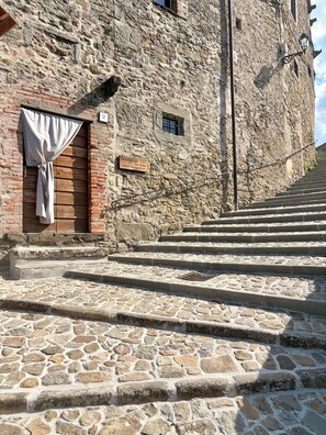 Una escalera de piedra que sube hacia un edificio con una puerta de madera y un letrero que señala un lugar para fotografías.