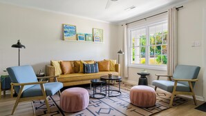 Ein Wohnzimmer mit einer Couch, zwei Sesseln, einem Couchtisch und einem Teppich.