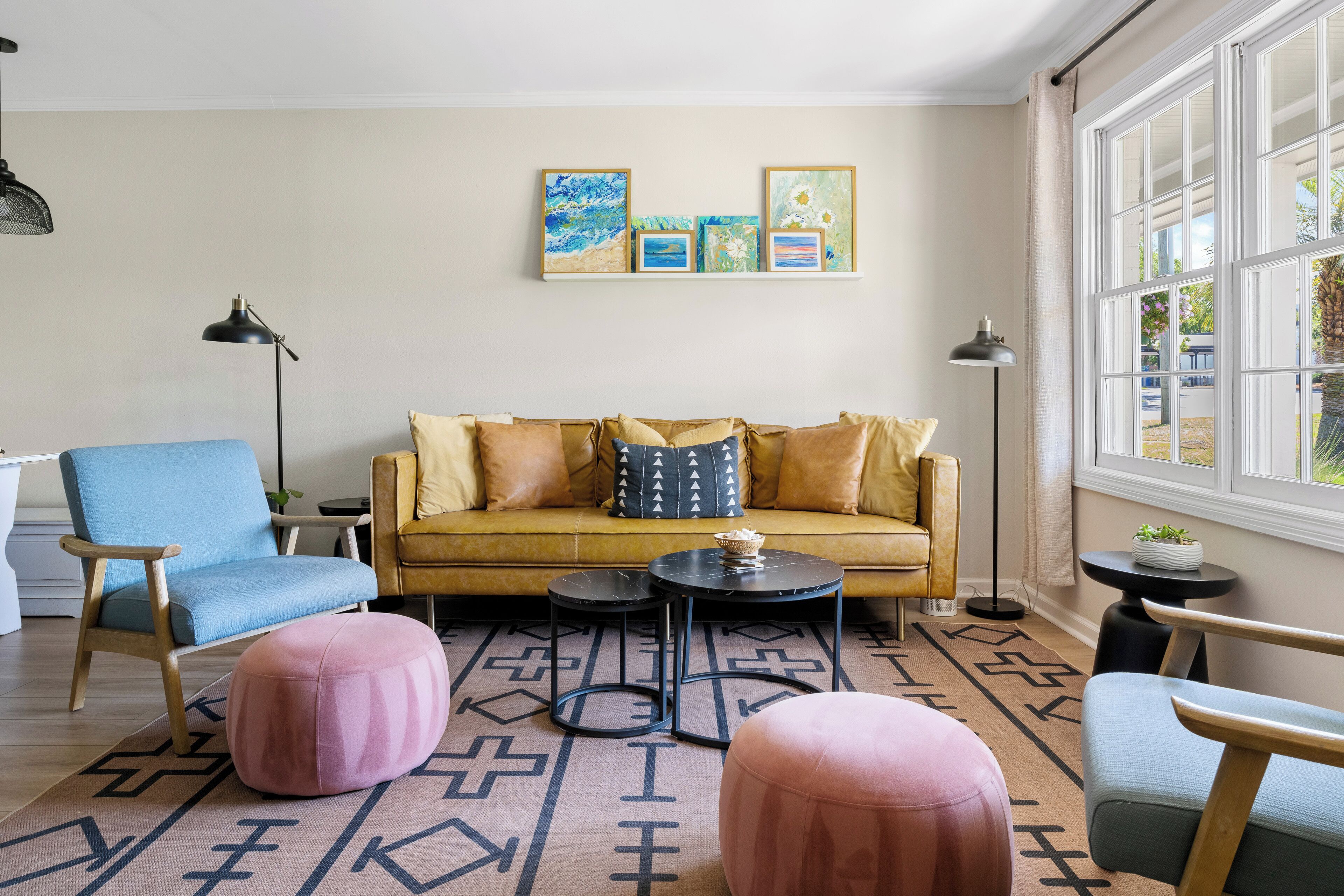 Een woonkamer met een bank, twee stoelen, een salontafel en een kamerkleed met dessin.