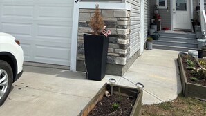 A two-story house with a garage, a stone accent wall, and a front door. - Beautiful, quiet, clean, cozy and affordable house to host at least 10 guest. (Grande Prairie)