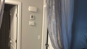 A hallway with a door, a thermostat, and a power outlet. - Beautiful, quiet, clean, cozy and affordable house to host at least 10 guest. (Grande Prairie)