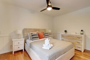 A bedroom with a bed, a nightstand, a dresser, a ceiling fan, and a wall-mounted lamp. - Farm House Cottage -  4 season Spa in Nature - Paddleboards - In&out Fireplace (Entrelacs)