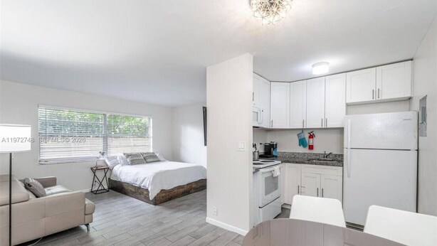 Un appartement compact comprenant un lit, une kitchenette, un coin repas et un petit espace de vie.