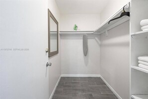 Ein kleines, abgeschlossenes Badezimmer mit Dusche, Spiegel, Handtuchhalter und Ablagefläche mit einem Handtuch.