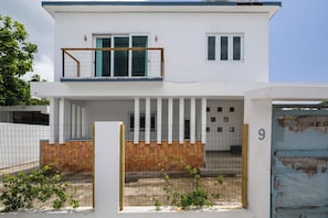 A two-story building with a balcony, a gated entrance, and a number '9' on the gate. - Villa Playa - Beach & Pool Apartments (San Juan)