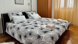 A bedroom with a bed, a wardrobe, a floor lamp, and a window with curtains. - Magic Sunset – apartman za 4 osobe s velikim balkonom i orbitrekom (Pirovac)