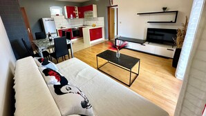 A modern living room with a sofa, a coffee table, and a TV area. - Magic Sunset – apartman za 4 osobe s velikim balkonom i orbitrekom (Pirovac)
