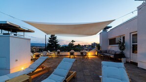 An outdoor patio with lounge chairs, a table, and a canopy. - Luxury Aparthotel MejtasHills - Old Town (Sarajevo)