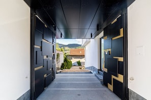 A corridor with a view of a mountain and a building in the distance.
