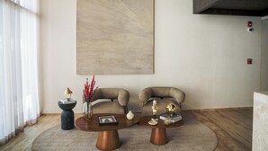 Ein modernes Wohnzimmer mit zwei Sofas, einem großen abstrakten Gemälde und einem Couchtisch mit Dekoration.