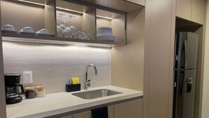 Una cocina moderna con un lavaplatos de acero inoxidable, una cafetera y un refrigerador empotrado.