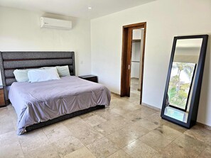 Une chambre à coucher avec un lit, une table de chevet et un grand miroir.