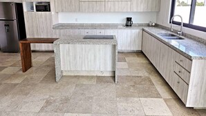 Eine moderne Küche mit Granitarbeitsplatten, Edelstahlgeräten und hellen Holzschränken.