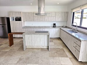 A modern kitchen with granite countertops, stainless steel appliances, and light wood cabinetry. - Modern Villa · Private Pool · La Cruz Marina (Cruz de Huanacaxtle)