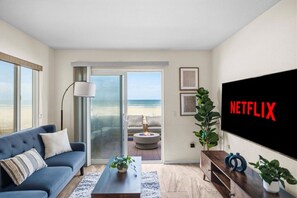 Ein Wohnzimmer mit einer Couch, einem Couchtisch und einem Fernsehbildschirm, der 'NETFLIX' anzeigt.