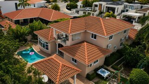 A multi-story residential building with a swimming pool, surrounded by lush greenery. - Tropical 3-Bedroom Villa with Pool Next to the Jan Thiel Salt Flats (Willemstad)