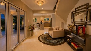 A modern living room with a sofa, a coffee table, a decorative vase, and a bookshelf. - Tropical 3-Bedroom Villa with Pool Next to the Jan Thiel Salt Flats (Willemstad)
