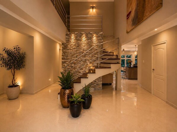 A modern interior with a polished floor, a spiral staircase, and potted plants. - Tropical 4-Bedroom Villa with Pool Next to the Jan Thiel Salt Flats + Rental Car (Willemstad)