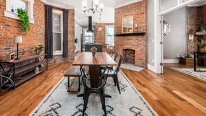 A dining area with a wooden table, chairs, and a chandelier. - Historic Home Near Downtown - Sleeps 14 - Arcade (Columbus)