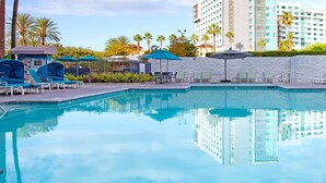 A swimming pool with lounge chairs and umbrellas, surrounded by palm trees and a Marriott hotel in the background. - Wyndham Large Luxury 2 Bedroom Suite w/Kitchen Next to Disneyland. Book by 6/29 (Anaheim)
