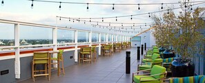 A rooftop terrace with a row of chairs and tables, a view of the city, and string lights. - Luxury Worldmark by Wyndham Large 2 Bedroom Suite w/Kitchen Next to Disneyland. (Anaheim)