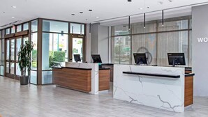 A modern reception desk with a marble design, a logo on the wall, and a large window with blinds. - Wyndham Large Luxury 2 Bedroom Suite w/Kitchen Next to Disneyland. Book by 6/29 (Anaheim)