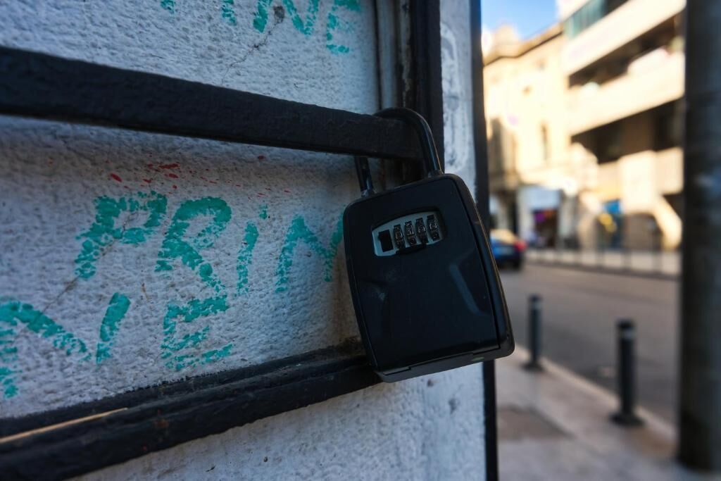 A security keypad attached to a wall with a metal frame.