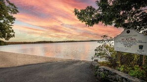 Zonsondergang boven het Wequaquet Lake, met een bord waarop staat dat jetski's verboden zijn en een snelheidslimiet van 35 mijl per uur.