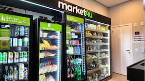 A market with refrigerated beverage dispensers and shelves stocked with snacks and drinks.