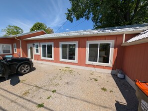 Ein eingeschossiges Gebäude mit roter Fassade, weißen Verzierungen und zahlreichen Fenstern.