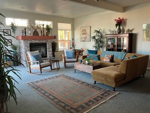 Una sala de estar con chimenea, sofás, sillones y una mesa de centro.