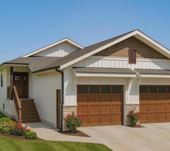 A two-story house with a front entrance, a staircase, and two garage doors.