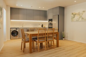 Une cuisine moderne avec des meubles gris, un four encastré et un four à micro-ondes.
