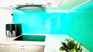 A kitchen with white cabinets, a black appliance, and a potted plant on the counter. - 3-bedroom house in welcoming Thanh Dien with AC comfort (Thanh Dien)