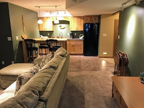 Eine moderne Küche mit Holzausstattung, einem schwarzen Kühlschrank und einem Essbereich mit Holztisch und Stühlen.