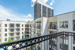A multi-story building with balconies, large windows, and a clear sky. - Urban Houston Stay 1BR • Balcony • Fast Wi-Fi  Laundry (Houston)