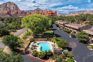 Ein Resort mit Schwimmbad, Gästezimmern und einer Bergkulisse.