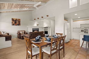 A modern living room with a fireplace, dining table, and kitchen area. - West Sedona Condo, Views+ Bonus Room! (Sedona)